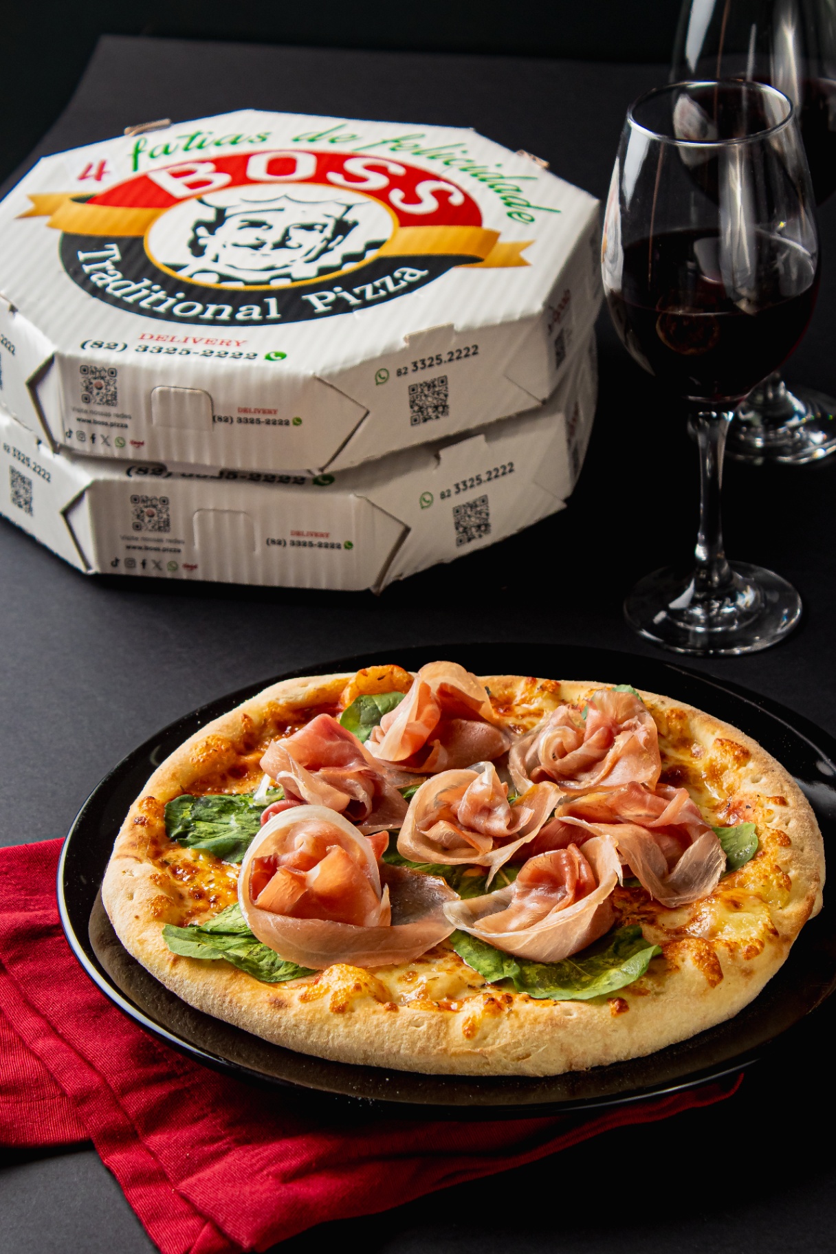 Pizza de parma com caixas Boss ao fundo